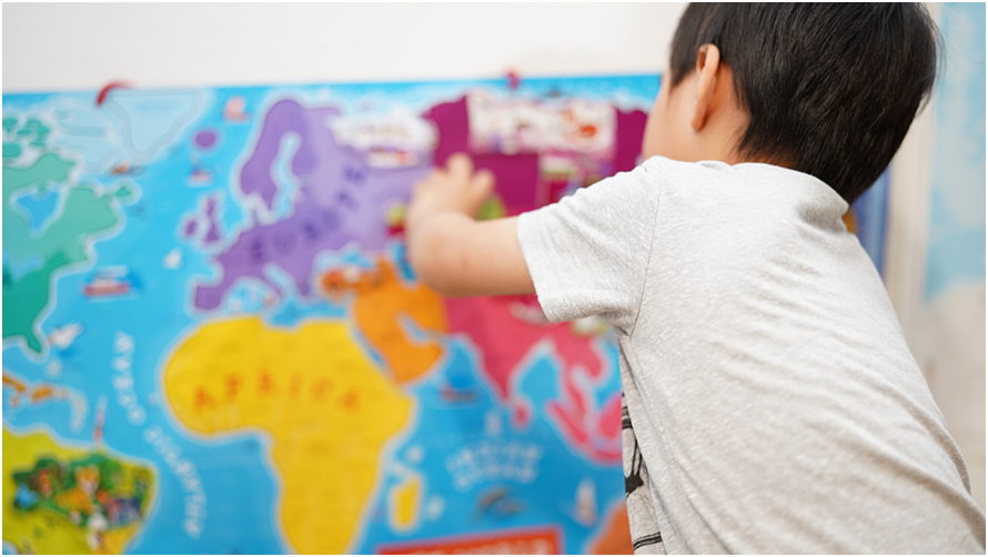 世界地図を指さしている子供の後姿