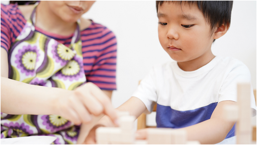 子供が積み木で遊んでいる様子と大人がサポートしている場面