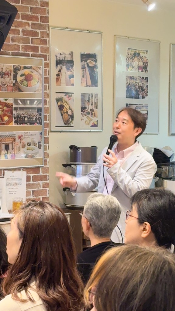 料理教室で講演している男性。