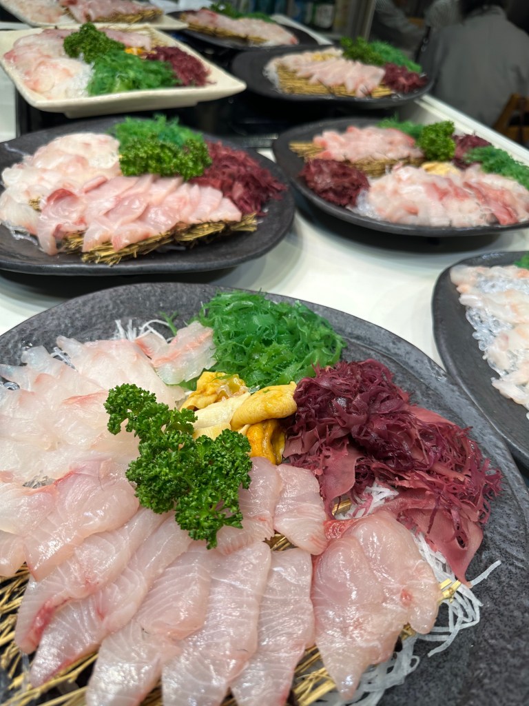 色とりどりの刺身と野菜が盛り付けられた皿のクローズアップ。